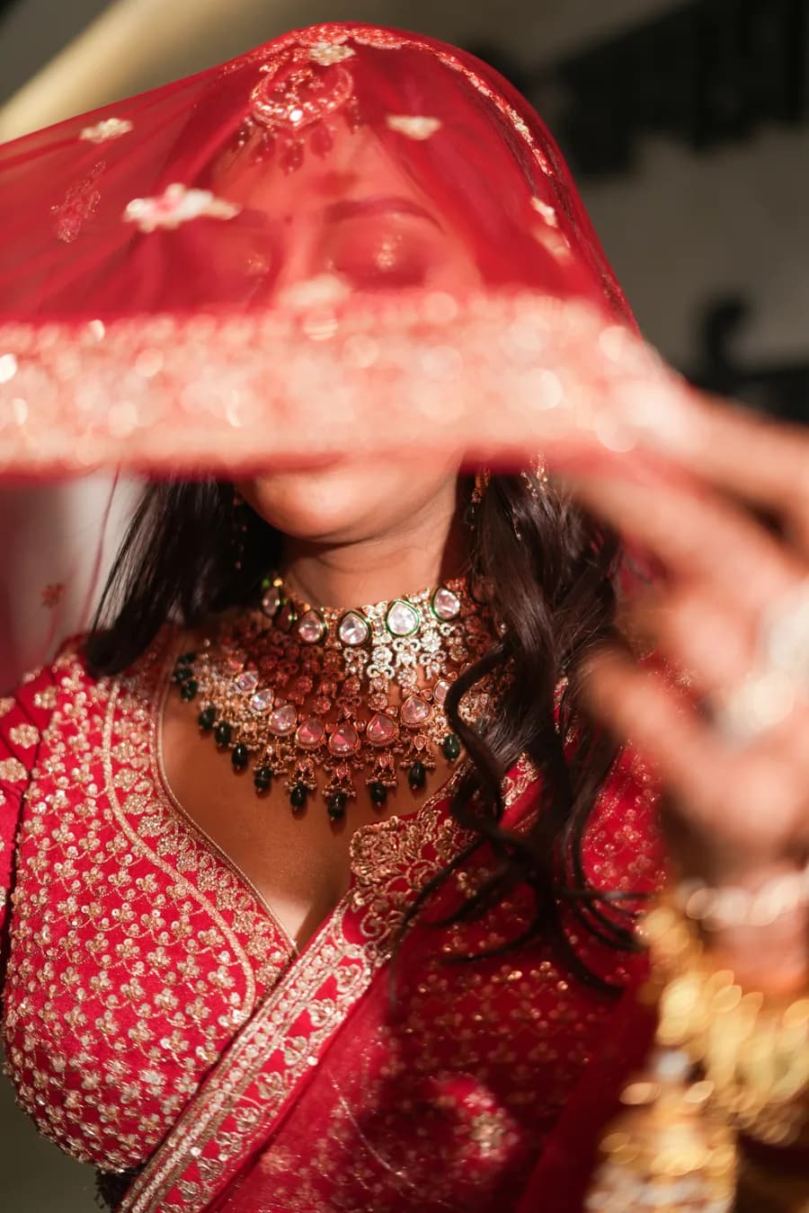 Bengali bride in red saree and white flowers during wedding day ritual