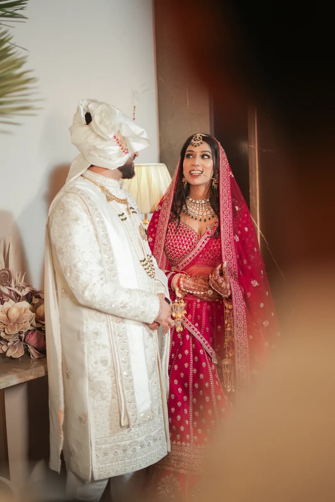 Bride's getting-ready moment with mehndi, makeup artist, and close family in bridal room