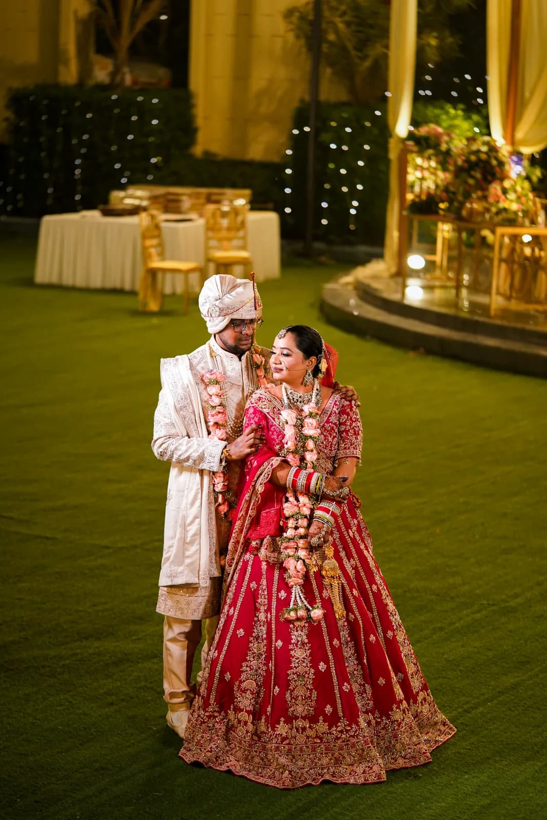 Couple in wedding attire at a Dehradun hillside wedding venue or by the Ganges River with mist-covered mountains and golden light