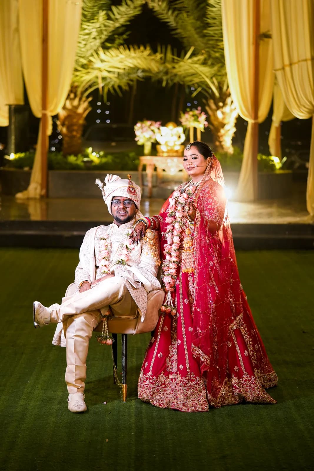 Sikh couple in traditional wedding attire at the Golden Temple or Amritsar gurudwara with warm golden light